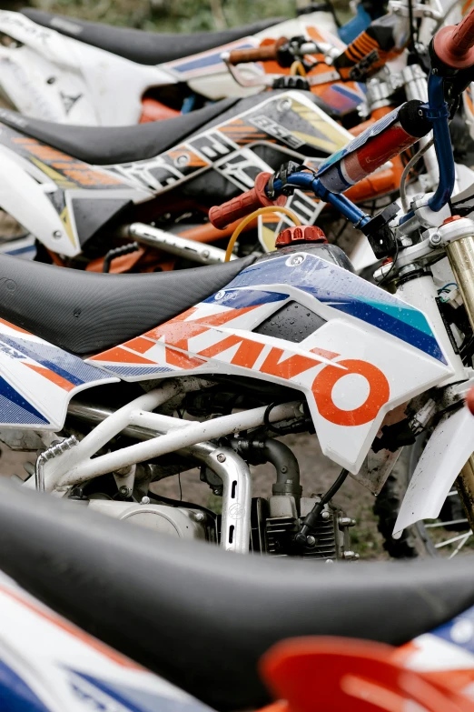 a row of dirt bikes parked next to each other, white and orange breastplate, micro detail, square, kawaai