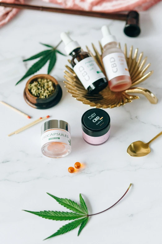 a variety of skin care products laid out on a table, by Julia Pishtar, unsplash, renaissance, marijuana themed, liquid gold, on a white background, candy treatments