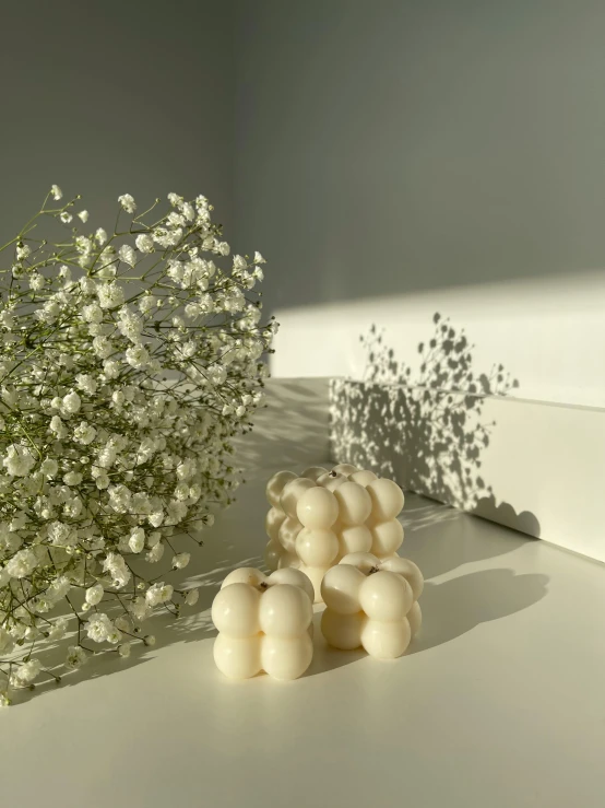 a bunch of baby's breath sitting on top of a table, a marble sculpture, by Emma Andijewska, carved soap, studio quality smooth render, in a row, puffballs