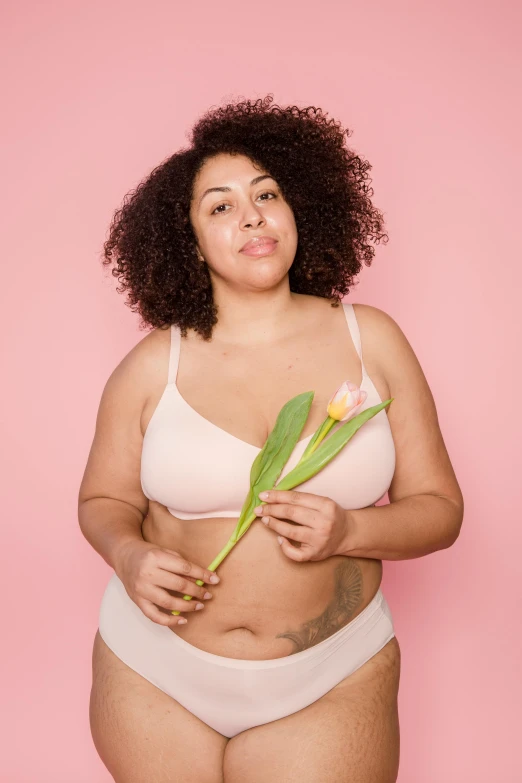 a woman in a white underwear holding a flower, her belly is fat and round, promo image, mixed-race woman, pink skin