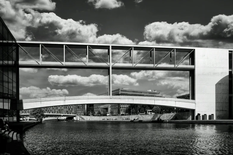 a black and white photo of a bridge over a body of water, inspired by Thomas Häfner, bauhaus, palast der republik in berlin, under blue clouds, shipyard, photo taken in 2 0 2 0