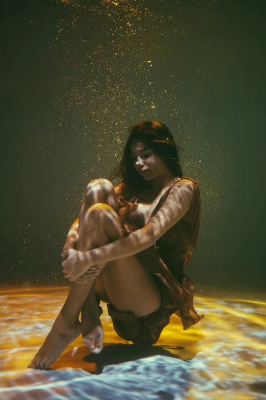 a woman sitting on top of a bed under water, inspired by Elsa Bleda, unsplash contest winner, conceptual art, gold skin, floating dust particles, stands in a pool of water, shot at dark with studio lights