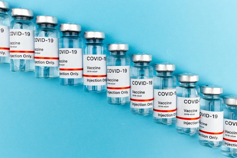 a row of vials filled with vaccines on a blue background, a picture, visual art, thumbnail, covid, shkkeled in the voied, round bottle
