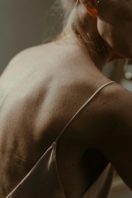 a woman brushing her hair in front of a mirror, by Anna Boch, unsplash, showing her shoulder from back, many scars. cinematic lighting, wrinkled muscles skin, soft light.4k