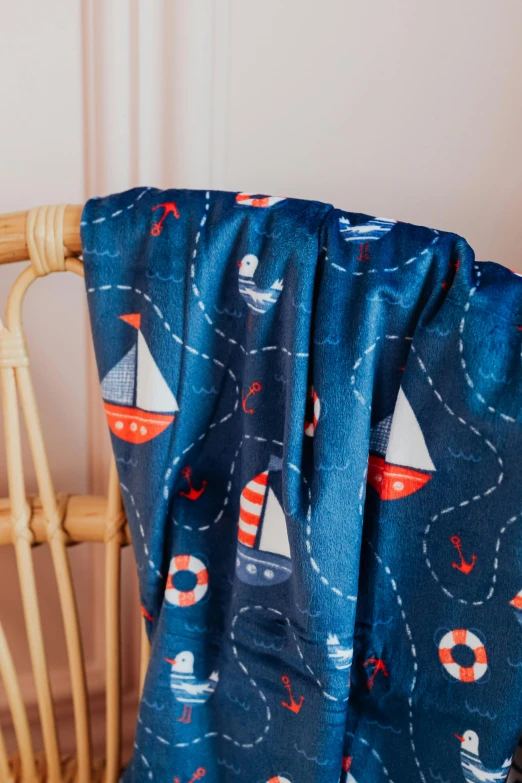 a blanket sitting on top of a wooden chair, a cartoon, sailing boats, close up shot from the side, navy, slide show