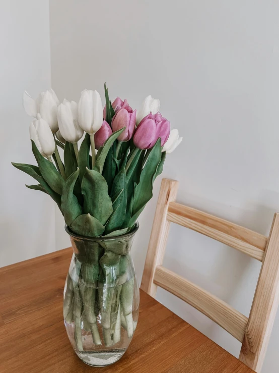 a vase filled with white and pink tulips sitting on top of a wooden table, unsplash, 👰 🏇 ❌ 🍃, having an awkward dinner date, 😭 🤧 💔, extremely pale