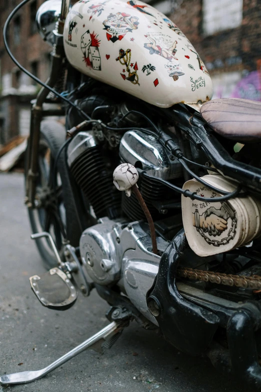 a close up of a motorcycle parked on a street, auto-destructive art, with white kanji insignias, intricate details and ornaments, color photo, indian