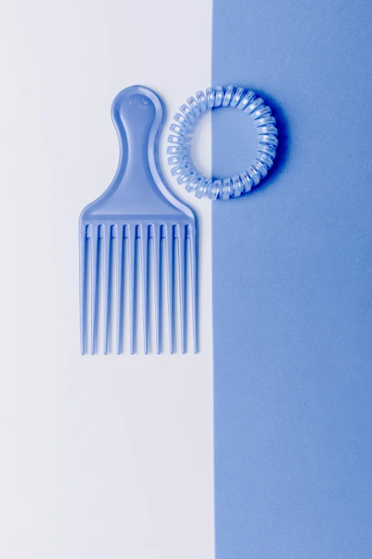 a comb and a ring on a blue and white background, inspired by Milton Glaser, plasticien, soft volume absorbation, ((blue)), afro comb, 15081959 21121991 01012000 4k