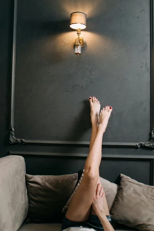 a woman laying on a couch with her legs up, inspired by Elsa Bleda, trending on pexels, arabesque, darkslategray wall, wall ], happy toes, ilustration