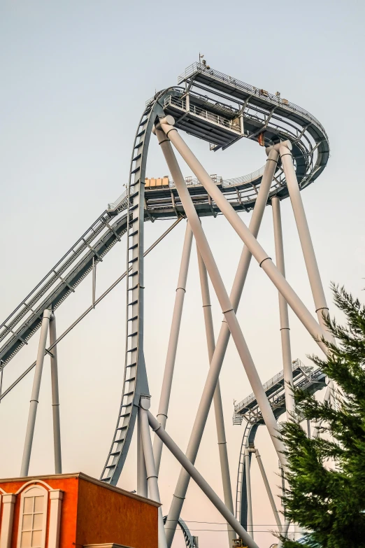 a roller coaster in an amusement park with trees in the foreground, trending on reddit, photorealism, solid gray, gondor, taken at golden hour, olympus platform