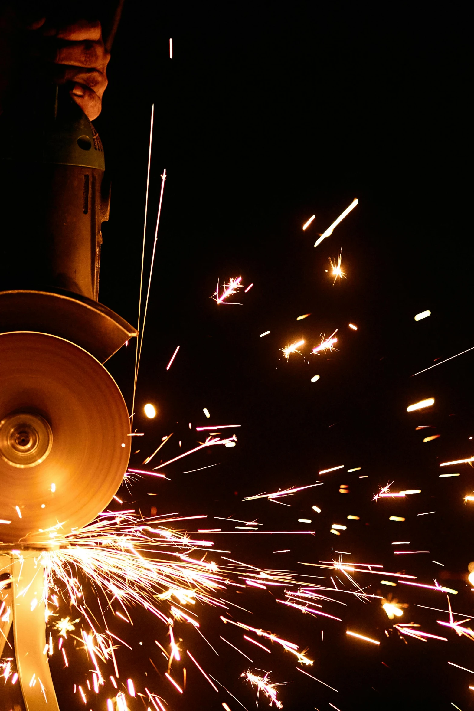 a man grinding a piece of metal with a grinder, an album cover, pexels contest winner, process art, fireworks, steel mill, ilustration, museum quality photo