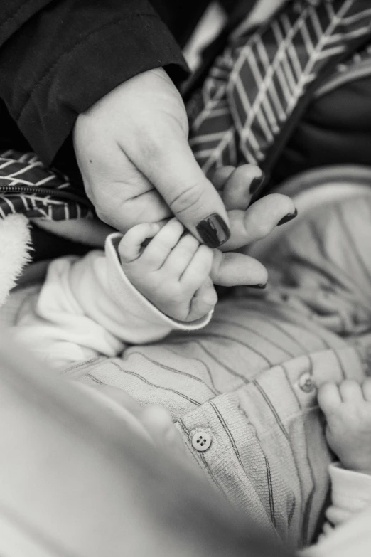 a black and white photo of a baby in a car seat, pexels, process art, painted nails, husband wife and son, touching her clothes, detailed close foot shot