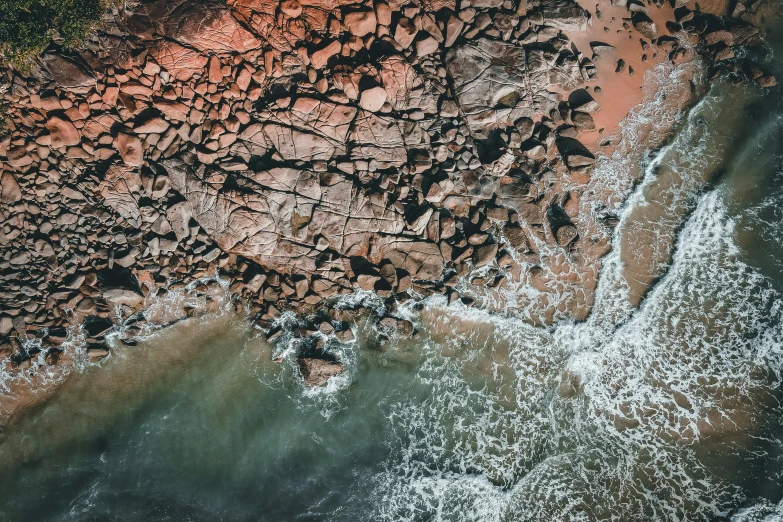 a bird's eye view of a rocky beach, pexels contest winner, red sandstone natural sculptures, thumbnail, turbulent water, slightly pixelated