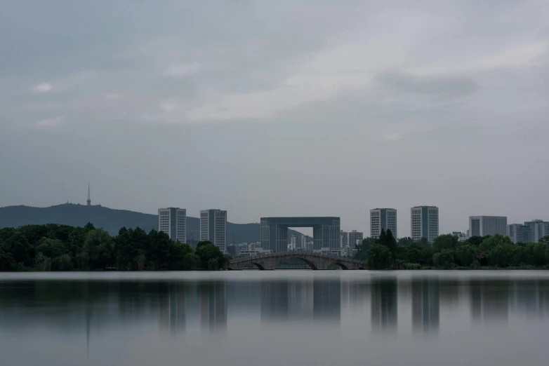 a large body of water with buildings in the background, a picture, inspired by Tadao Ando, hangzhou, low quality photo, low iso, all buildings on bridge