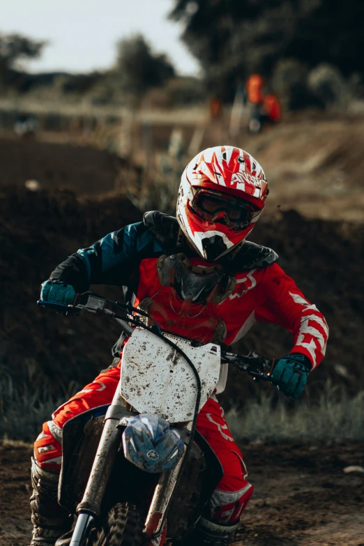 a person riding a dirt bike on a dirt track, pexels contest winner, white and red armor, kids, up close, goggles