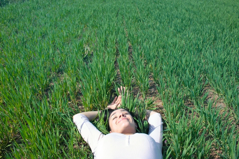 a woman laying in a field of green grass, unsplash, renaissance, 2000s photo, farming, in spain, 2 0 0 0's photo