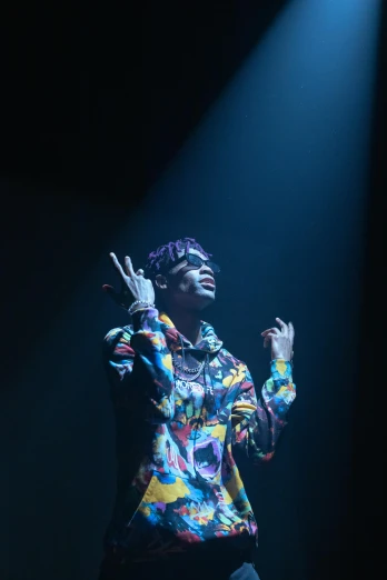 a woman standing on top of a stage holding a microphone, an album cover, trending on pexels, holography, wiz khalifa, wearing a colorful coogi sweater, dramatic lighting !n-9, guy using the purple fancy suit