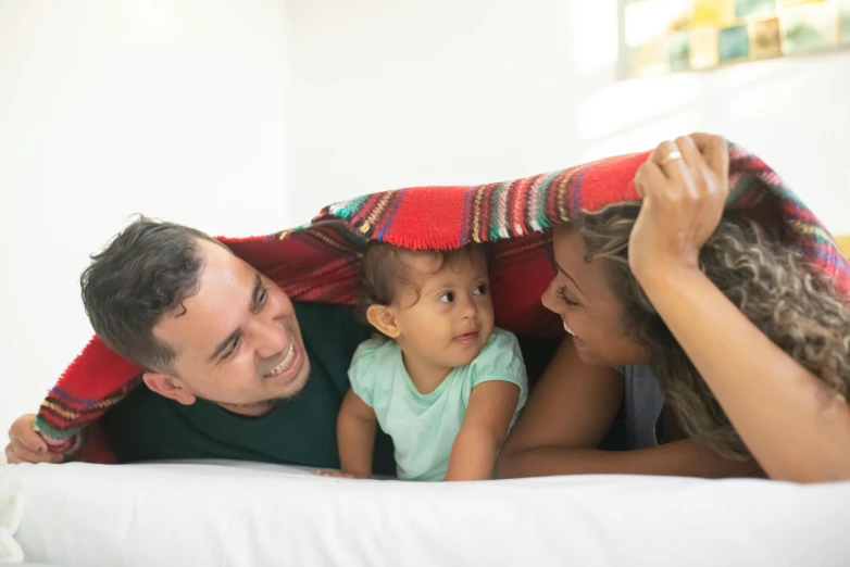a man and woman laying on a bed with a baby, pexels contest winner, hispanic, square, tiny girl looking on, canopy