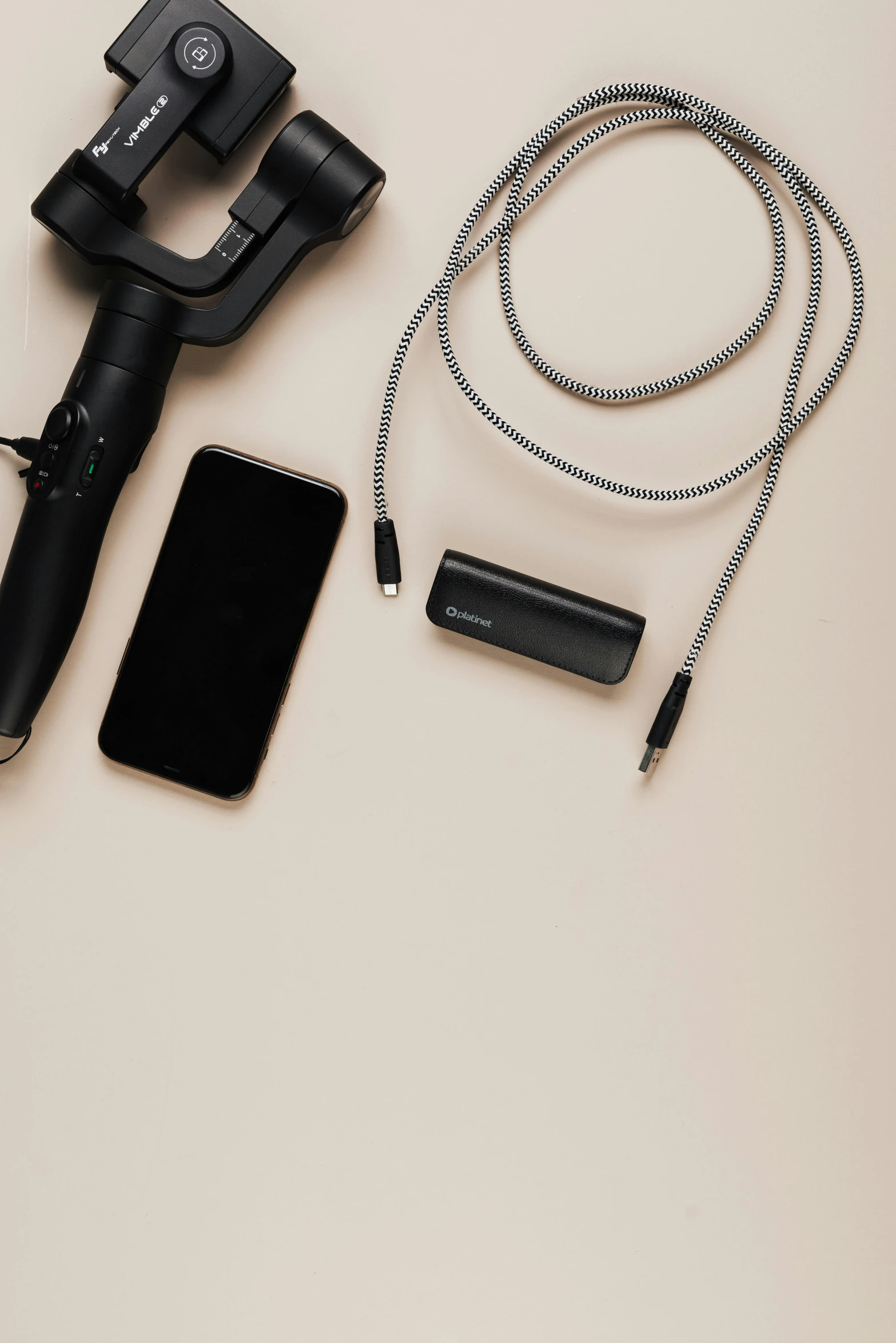 a cell phone sitting on top of a table next to a camera, various items, riding, headset, detailed product image