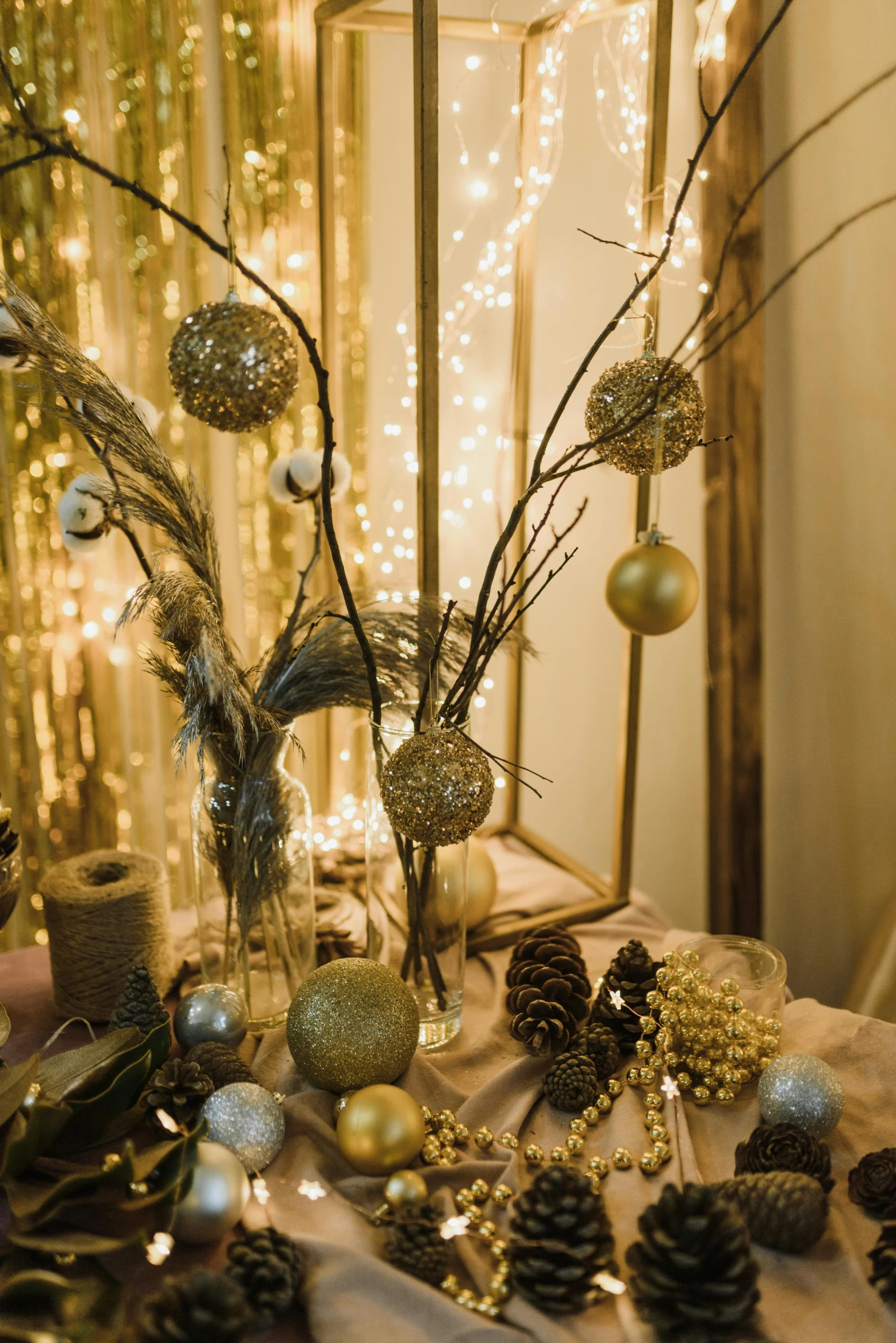 a table topped with a vase filled with pine cones, inspired by Patrick Dougherty, pexels, baroque, string lights, golden orbs, pastel', contain