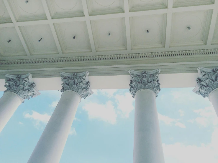 a close up of a building with columns and a sky background, by Carey Morris, pexels contest winner, neoclassicism, inside white room, background image, square, wide high angle view