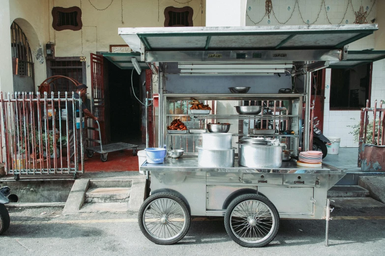 a food cart parked in front of a building, pexels contest winner, dau-al-set, pots and pans, malaysian, full body image, b - roll