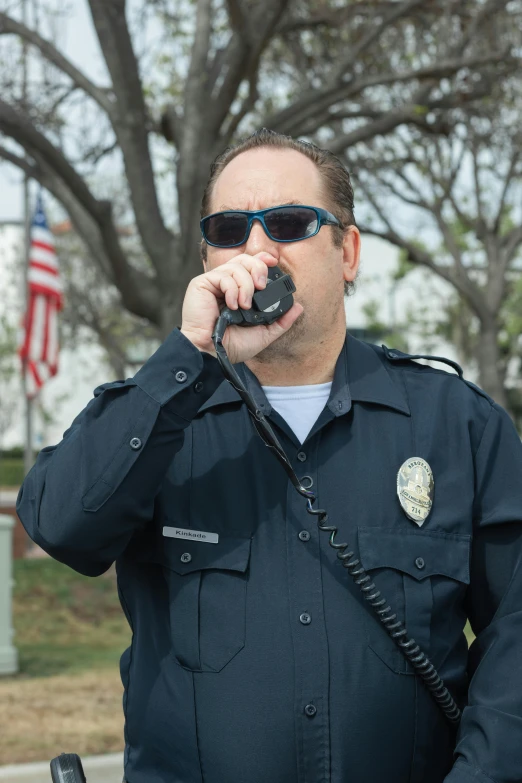 a police officer talking on a cell phone, by Arnie Swekel, shutterstock, photorealism, clear sharp face of todd solondz, inauguration, oceanside, wearing shades