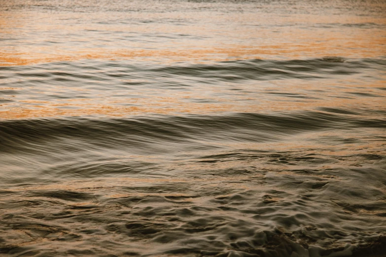 a person riding a surfboard on top of a body of water, pexels contest winner, tonalism, flowing salmon-colored silk, late summer evening, swirly ripples, shoreline
