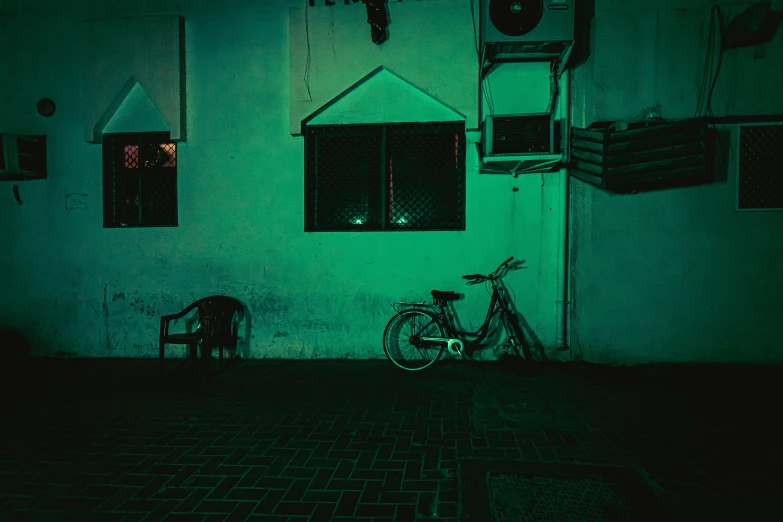 a bike is parked in front of a building, inspired by Elsa Bleda, pexels contest winner, green scary lights, old jeddah city street, harsh flash photo at night, afternoon hangout