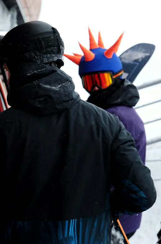 a group of people standing on top of a snow covered slope, featured on reddit, graffiti, snout under visor, wearing spiky, close-up shot from behind, orange balaclava