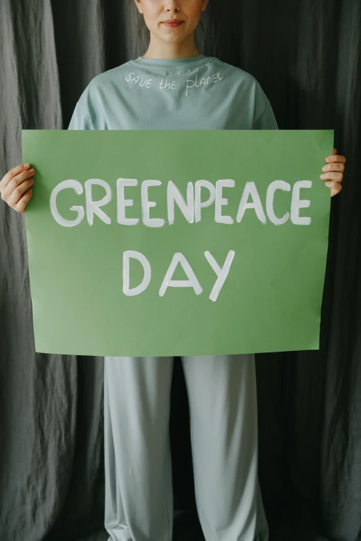 a woman holding a green peace day sign, pexels, renaissance, instagram post, clean energy, its name is greeny, trident