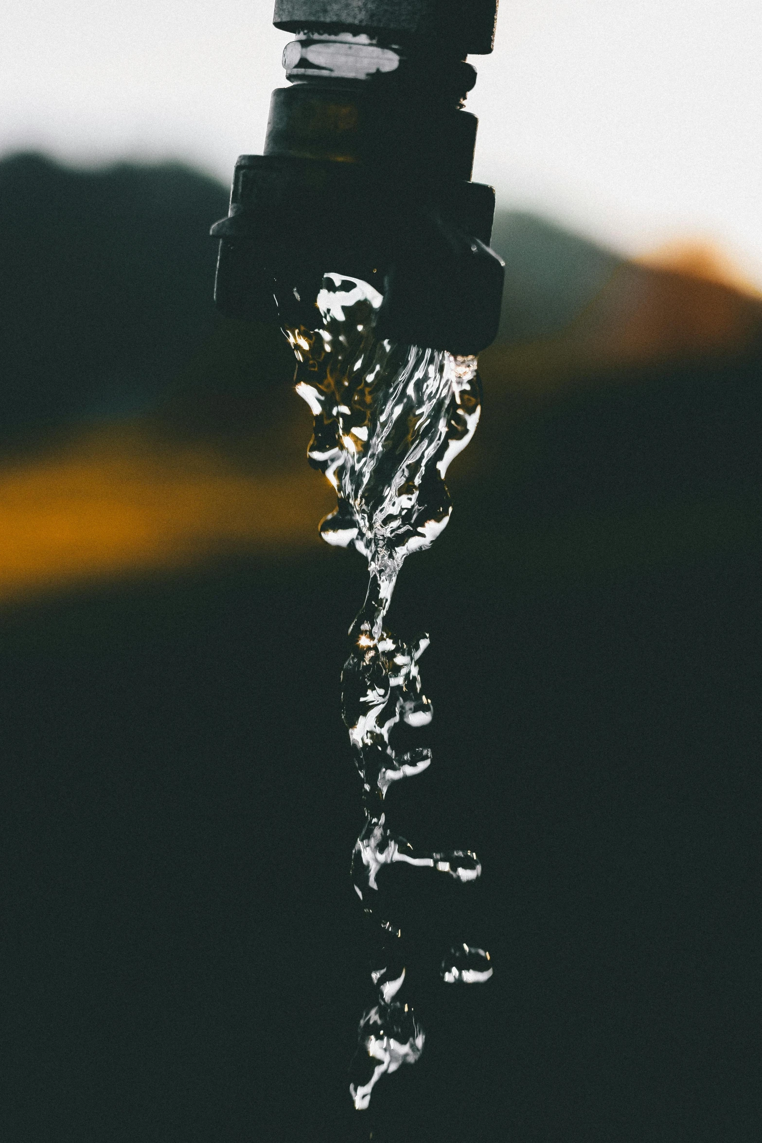 a close up of a faucet with water coming out of it, by Niko Henrichon, pexels contest winner, black-water-background, transhumanist hydration, hanging veins, perfectly poised