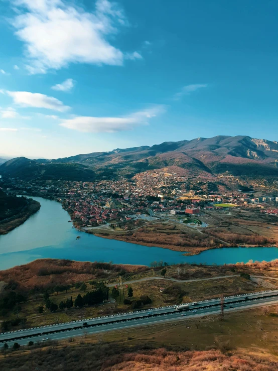 a train traveling through a rural countryside next to a lake, by Muggur, pexels contest winner, renaissance, super wide view of a cityscape, bosnian, 4 k cinematic panoramic view, square