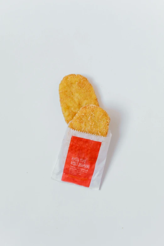 a bag of potato chips sitting on top of a white surface, by Maeda Masao, kfc chicken, one tomato slice, very tiny, no text