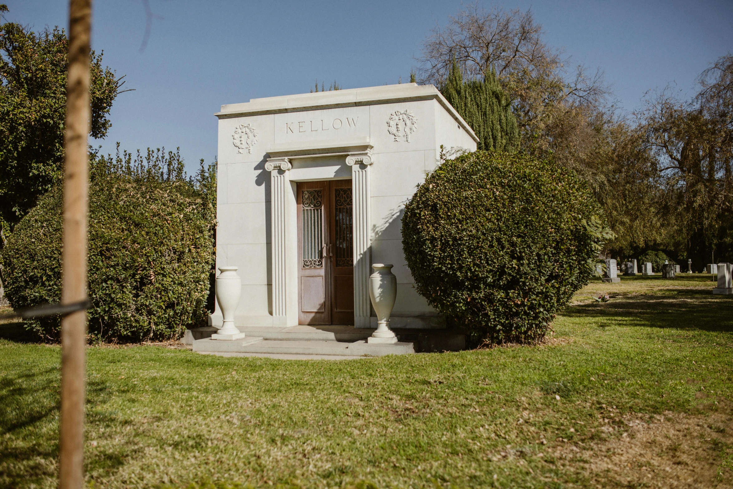 a small white building sitting on top of a lush green field, a marble sculpture, by Kristin Nelson, unsplash, inside a tomb, los angelos, felix kelly, graveside