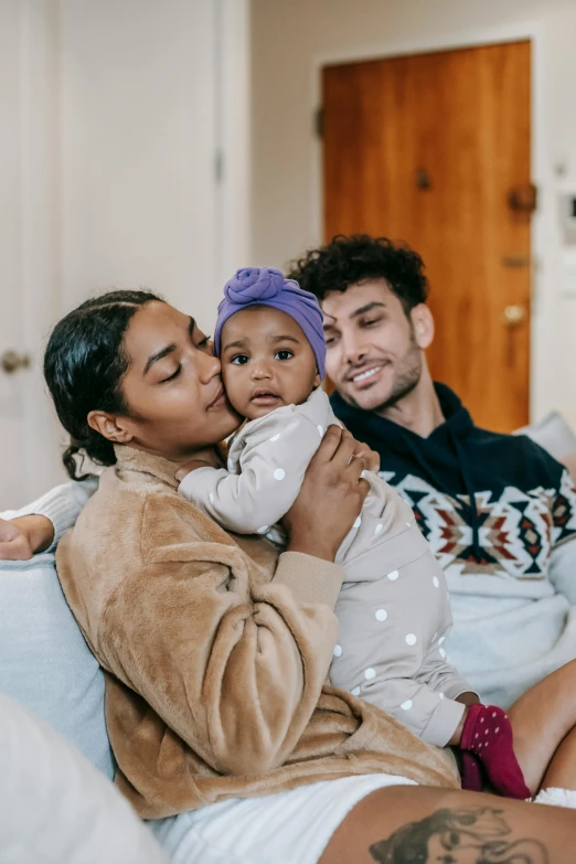 a man and woman sitting on a couch with a baby, pexels contest winner, renaissance, mixed-race woman, holding each other, manuka, non-binary