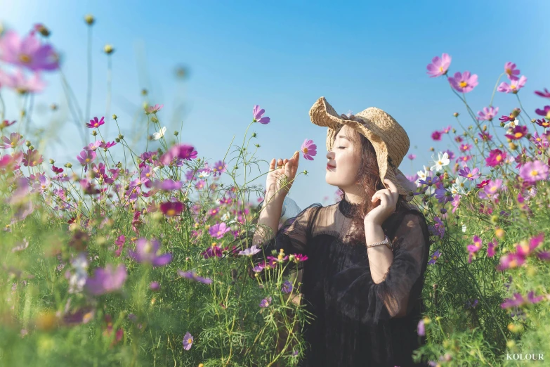 a woman wearing a straw hat in a field of flowers, pexels contest winner, miniature cosmos, smelling good, avatar image, wearing black old dress and hat