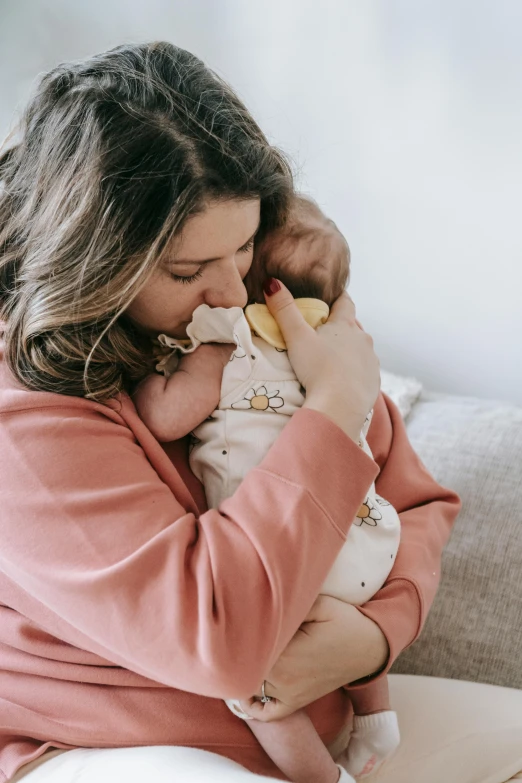 a woman sitting on a couch holding a baby, pexels contest winner, manuka, sleepy feeling, eating, holding each other