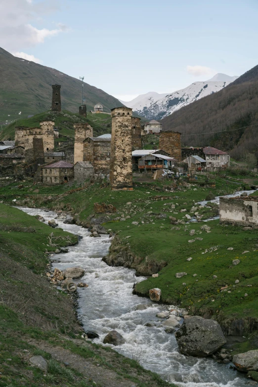 a river running through a lush green valley, by Muggur, hurufiyya, ruined buildings, three towers, town, atlach - nacha