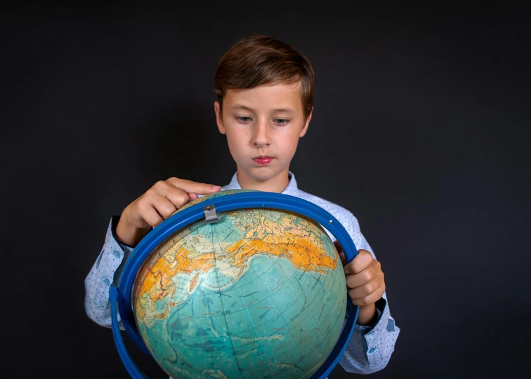 a young boy holding a globe in his hands, an album cover, by Adam Marczyński, pexels contest winner, 15081959 21121991 01012000 4k, well-groomed model, thumbnail, school class