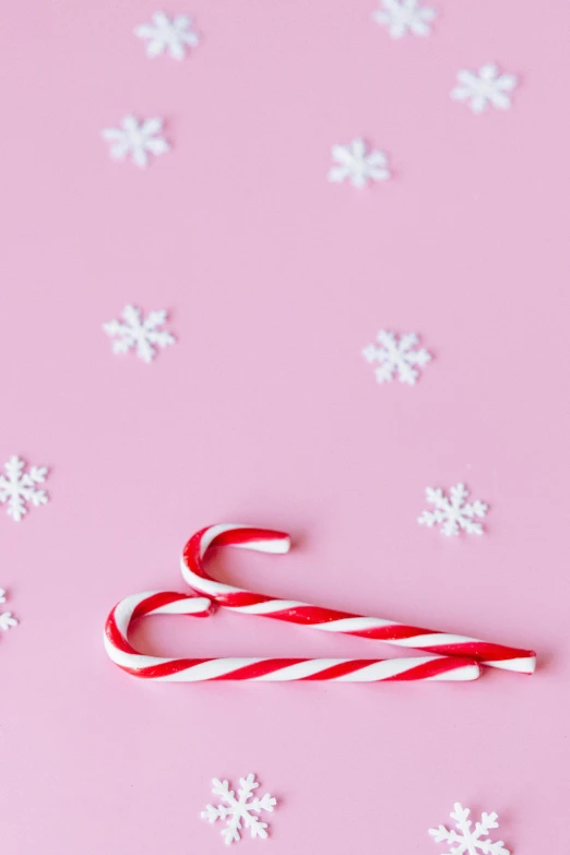 a candy cane on a pink background with snowflakes, pexels, hurufiyya, thumbnail, background image, flatlay, multiple stories