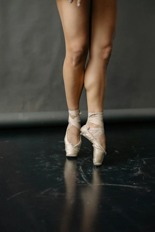 a close up of a woman's legs in ballet shoes, by Elizabeth Polunin, trending on unsplash, standing up, cracked, studio photo, silk shoes