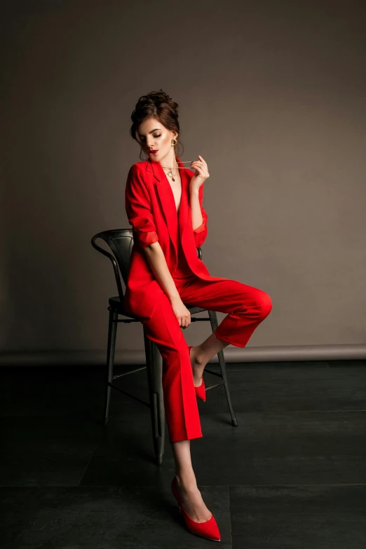 a woman in a red suit sitting on a chair, inspired by Jiang Tingxi, trending on pexels, jumpsuit, lily collins, formal wear, ny