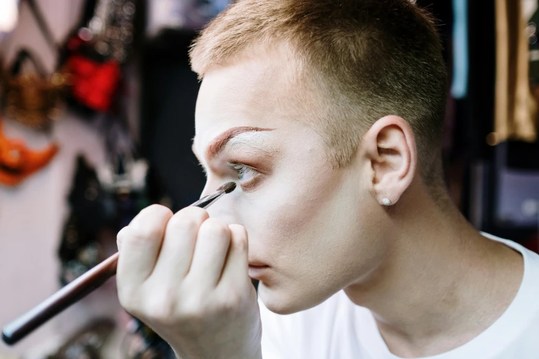 a close up of a person doing makeup, by Joe Bowler, lachlan bailey, confident looking, lee griggs, genderless