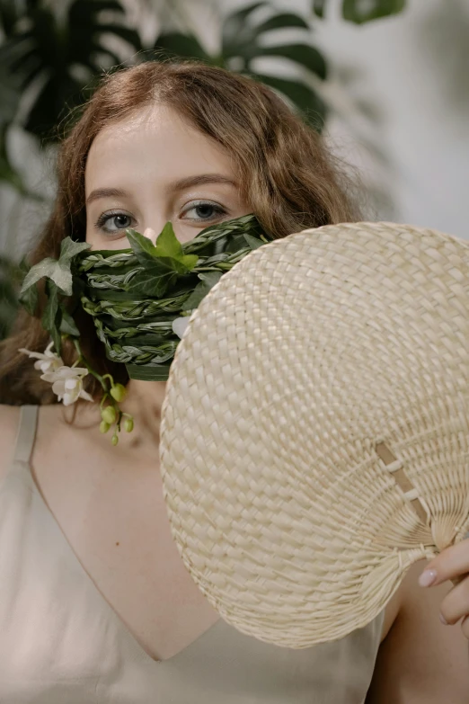 a woman covering her face with a straw hat, inspired by Konstantin Somov, unsplash, renaissance, video still, made of fabric, fern, wearing facemask