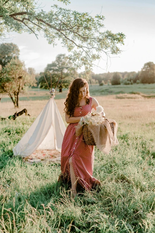 a woman standing in a field holding a teddy bear, unsplash, renaissance, teepee, rustic setting, long dress, carrying flowers