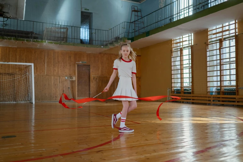 a young girl holding a red ribbon in a gym, by Dietmar Damerau, pexels contest winner, hyperrealism, ussr, wide skirts, anna nikonova aka newmilky, ( ( theatrical ) )