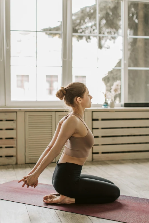 a woman sitting on a yoga mat in front of a window, pexels contest winner, waist reaching ponytail, ballerina, gif, physical : tinyest midriff ever