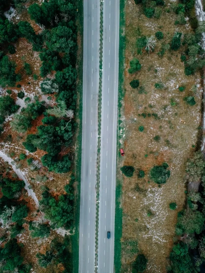 an aerial view of a road surrounded by trees, by Adam Marczyński, split in half, cinematic shot ar 9:16 -n 6 -g, canvas, vehicle