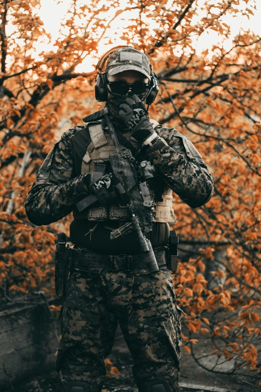 a man in camouflage standing in front of a tree, pexels contest winner, wearing tactical gear, autumn, spec - ops head, crypto